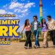 A group of friends laughing and standing in front of the amusement park rides at Wet’nJoy, Lonavala.