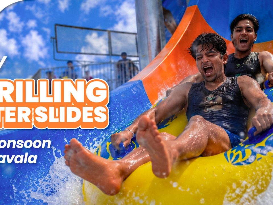 A group of people enjoying water slides and the rain at Wet'nJoy water park during a monsoon trip to Lonavala.